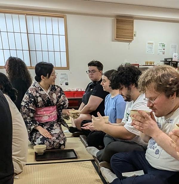 Students kneeling on floor with tea ceremony hostess