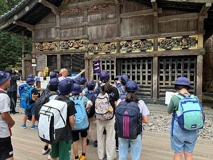 学生团体在东正神社入口前，导游指着建筑