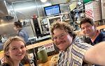 Three students posing for selfie at restaurant counter